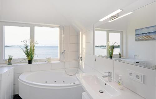 ein weißes Badezimmer mit einer Badewanne und einem Waschbecken in der Unterkunft Musica in Olpenitz