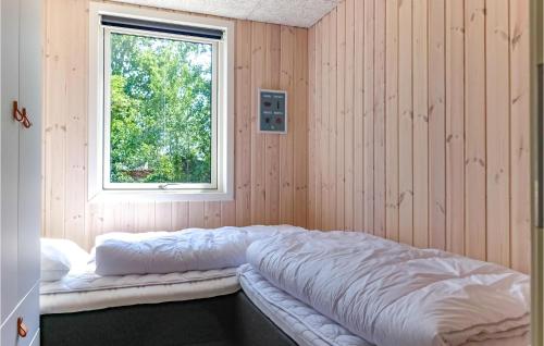 a bed sitting in a room with a window at Beautiful Home In Nex With Wifi in Snogebæk