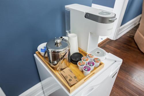 a stand with a coffee maker and donuts on it at Summit Street Inns in Winston-Salem