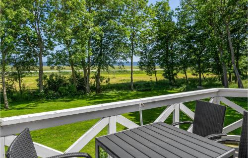 a table and chairs on a balcony with a view of a field at 3 Bedroom Cozy Home In Vesløs in Øsløs