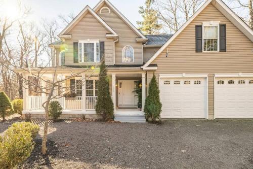a brown house with a white garage at Luxury 4 bedroom house in Pocono Mountains with Hottub in Golf Course Near Lake in Tobyhanna