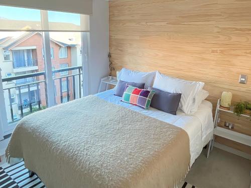 1 dormitorio con 1 cama grande y ventana grande en Puerto Varas, Departamento céntrico dos personas Yourhomepv en Puerto Varas