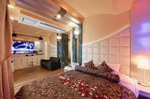 Un dormitorio con una cama grande con rosas. en ホテルパシオンリゾート, en Matsuyama