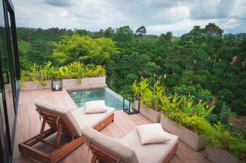 基姆巴亞的住宿－Amanatu Ecolodge & Spa，一个带椅子的庭院和一个位于甲板上的游泳池