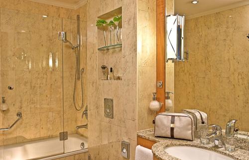 uma casa de banho com um chuveiro, um lavatório e uma banheira em Hotel Am Jägertor em Potsdam