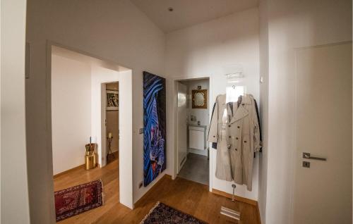 a hallway with white walls and a hallway with clothes hanging on the wall at Holiday-business Residence in Taufkirchen