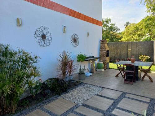 un patio con una mesa y algunas plantas en Maria Farinha casa en Maria Farinha