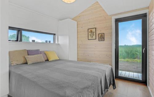 1 dormitorio con cama y ventana grande en Beautiful Home In Fllenslev With Wifi, en Føllenslev