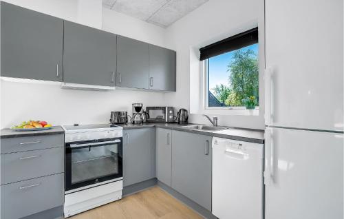a white kitchen with white appliances and a window at Cozy Home In Ringkøbing With Kitchen in Ringkøbing