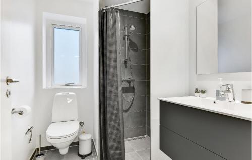 bagno bianco con servizi igienici e doccia di Marielyst a Svendborg