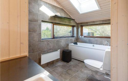 a bathroom with a toilet and a tub and a sink at Gorgeous Home In Nykbing Sj With Kitchen in Ebbeløkke