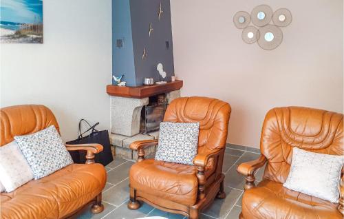 salon z 2 krzesłami i kominkiem w obiekcie 3 Bedroom Awesome Home In Saint-Carreuc w mieście Plouguenast Langast