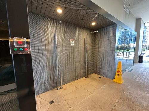 a shower stall in a building with a yellow cone at Prima Tower Apartment Face to Crown by GoodLive in Melbourne