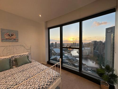 メルボルンにあるPrima Tower Apartment Face to Crown by GoodLiveのベッドと大きな窓のある寝室