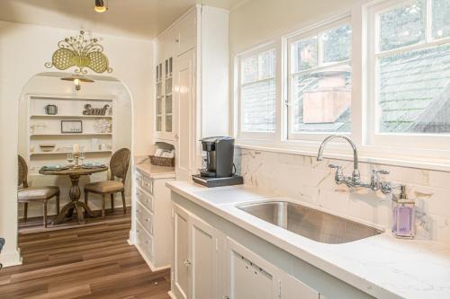 a white kitchen with a sink and a table at 3795 The Artist's Way apts in Carmel