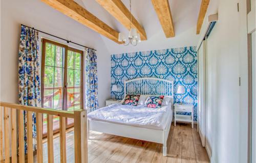 1 dormitorio con 1 cama y paredes azules en Lovely Home In Gietrzwald With Kitchen, en Gietrzwałd