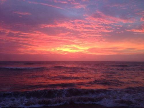 a sunset on the beach with the ocean at Sunset Beach Residence in Panadura
