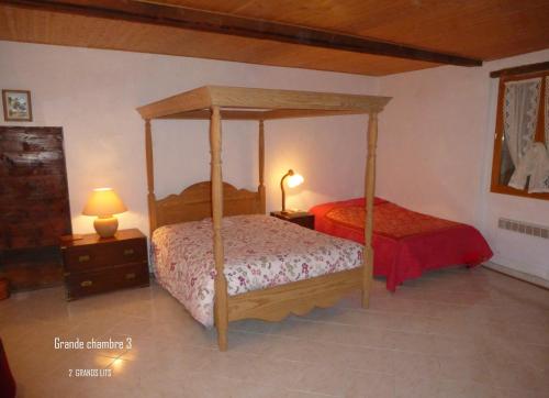- une chambre avec un lit à baldaquin et un couvre-lit rouge dans l'établissement Chateau Notre Dame de Sausses, à Sausses