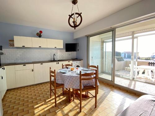 une cuisine avec une table et des chaises dans une pièce dans l'établissement Appartement T2 RDC - Mer à 200m, Animaux OK, Parking - FR-1-231-159, à Bretignolles-sur-Mer