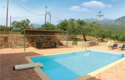 カルダミリにあるStunning Home In Kardamyli With 4 Bedrooms, Wifi And Swimming Poolの石造りの建物の前にあるスイミングプール(テーブル付)