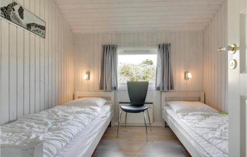 ヘンネ・ストランドにあるAwesome Home In Henne With 3 Bedrooms, Sauna And Wifiのベッドルーム1室(ベッド2台、椅子、窓付)