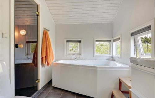 ヘンネ・ストランドにあるAwesome Home In Henne With 3 Bedrooms, Sauna And Wifiの窓付きのバスルーム(大きな白いバスタブ付)