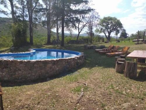 - une piscine dans une cour avec un mur en pierre dans l'établissement Casa de Montaña, à Córdoba