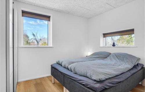 Cama en habitación blanca con 2 ventanas en Cozy Home In Hadsund With Wifi, en Hadsund