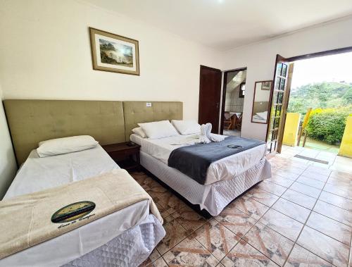 Ένα ή περισσότερα κρεβάτια σε δωμάτιο στο Pousada Casa de Campos Mountain House