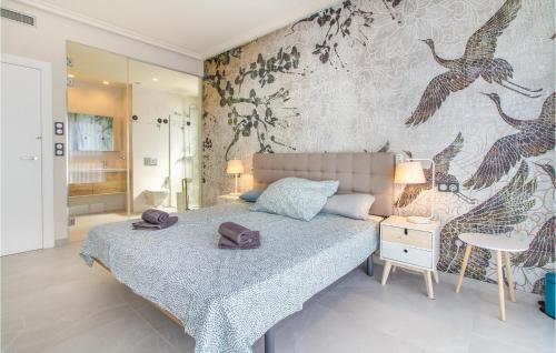 Stunning Home In Castalla With Wifi في كاستالا: غرفة نوم بسرير وجدار عليه طيور