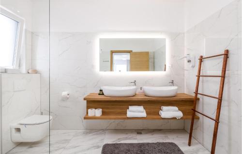 Baño con 2 lavabos y espejo en Amazing Home In Udbina With Indoor Swimming Pool, en Udbina
