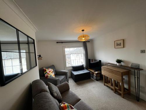 a living room with a couch and a table at The Farthings, Romsey Apartment in Romsey