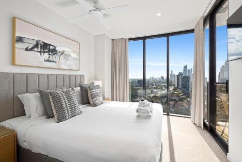 1 dormitorio con 1 cama blanca grande y ventana grande en CASSA ENCORE - Luxury Apartments Managed by The Cassa, en Gold Coast