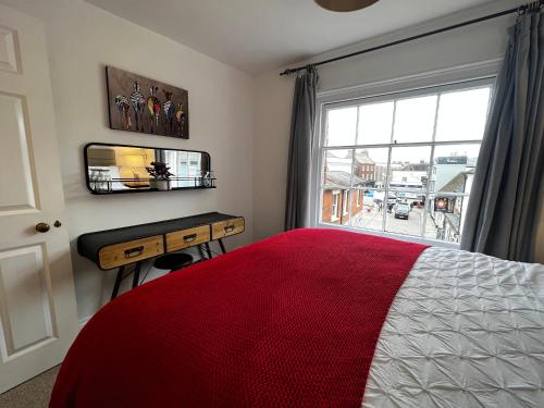 a bedroom with a bed and a desk and a window at The Farthings, Romsey Apartment in Romsey
