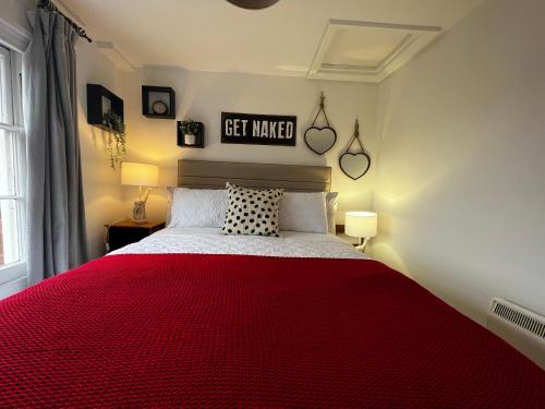 a bedroom with a red bed with a red blanket at The Farthings, Romsey Apartment in Romsey