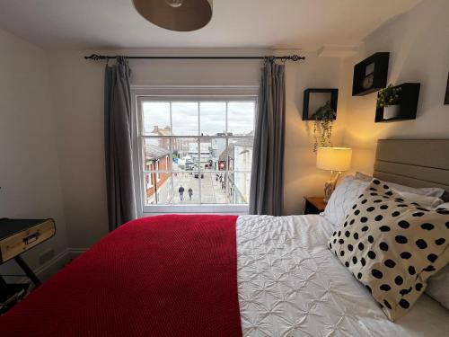 a bedroom with a bed and a large window at The Farthings, Romsey Apartment in Romsey