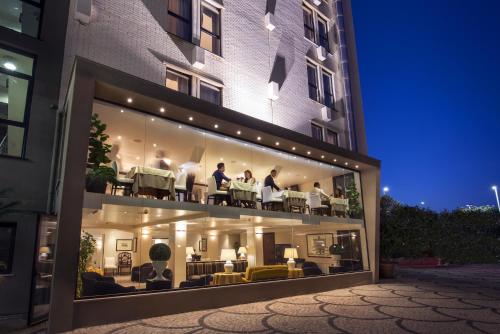 un groupe de personnes assises sur un balcon d'un bâtiment dans l'établissement Sardegna Hotel - Suites & Restaurant, à Cagliari