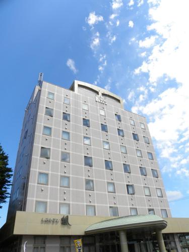 Yonezawa - Hotel / Vacation STAY 16072 في يونيزاوا: مبنى ابيض كبير عليه لافته