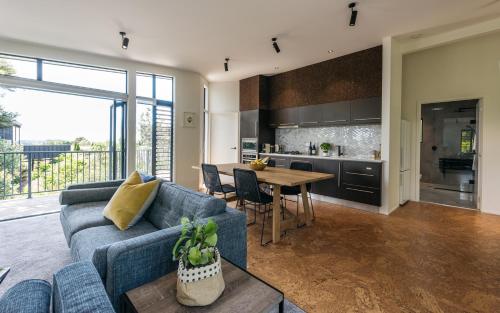 a living room with a blue couch and a table at Villas Waiheke in Onetangi