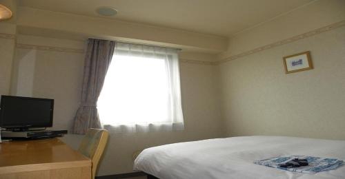 米澤的住宿－Yonezawa - Hotel / Vacation STAY 14338，一间卧室配有一张床、一张书桌和一个窗户。
