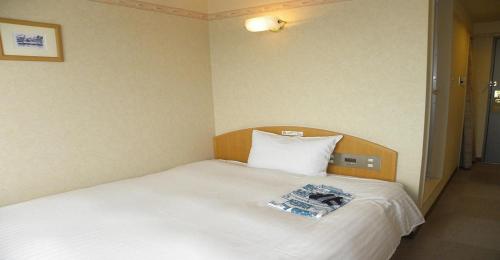 1 dormitorio con cama blanca y cabecero de madera en Yonezawa - Hotel / Vacation STAY 14338, en Yonezawa