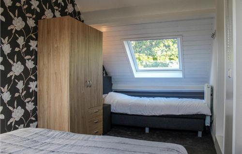 een slaapkamer met 2 bedden en een raam bij Boerenzwaluw in Kamperveen