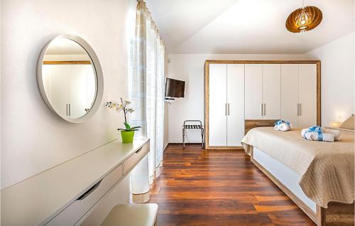 Schlafzimmer mit einem Bett und einem Spiegel in der Unterkunft 3 Bedroom Awesome Home In Vodnjan in Vodnjan