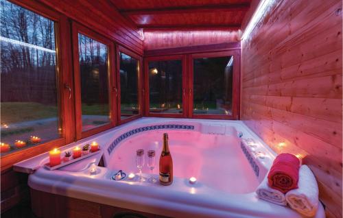 a bathroom with a tub with a bottle of champagne at Gorgeous Home In Brestovac With Sauna in Novo Zvecevo