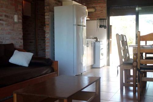 a living room with a couch and a table and a refrigerator at Praia - Proa al Mar in Maldonado