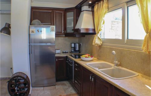 uma cozinha com um frigorífico de aço inoxidável e um lavatório em Amazing Home In Koroni With Wifi em Koroni