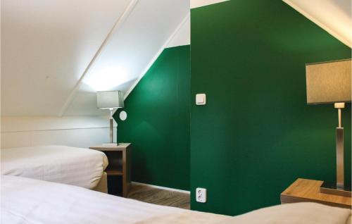 een kamer met 2 bedden en een groene muur bij Vossenhol in Ommen