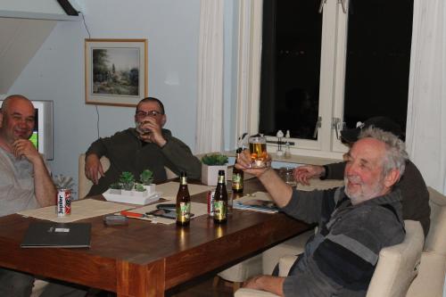 a group of men sitting around a table drinking beer at B&B Veluwemeerpension in Nunspeet