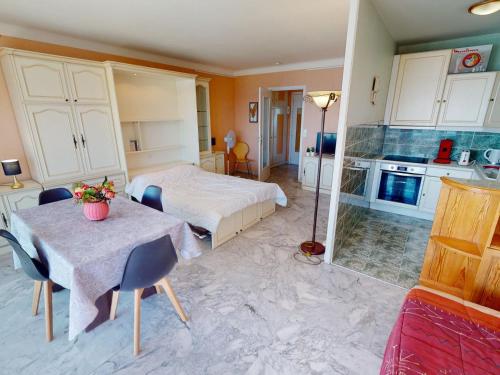 une chambre avec un lit et une table et une cuisine dans l'établissement Studio spacieux avec terrasse, parking, face mer, proche plages et commodités - FR-1-196-320, à Roquebrune-Cap-Martin