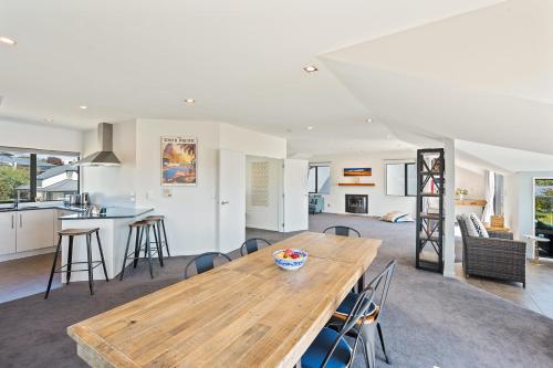 a kitchen and living room with a wooden table at IRONSIDE LAKEVIEW TOWNHOUSE in Wanaka